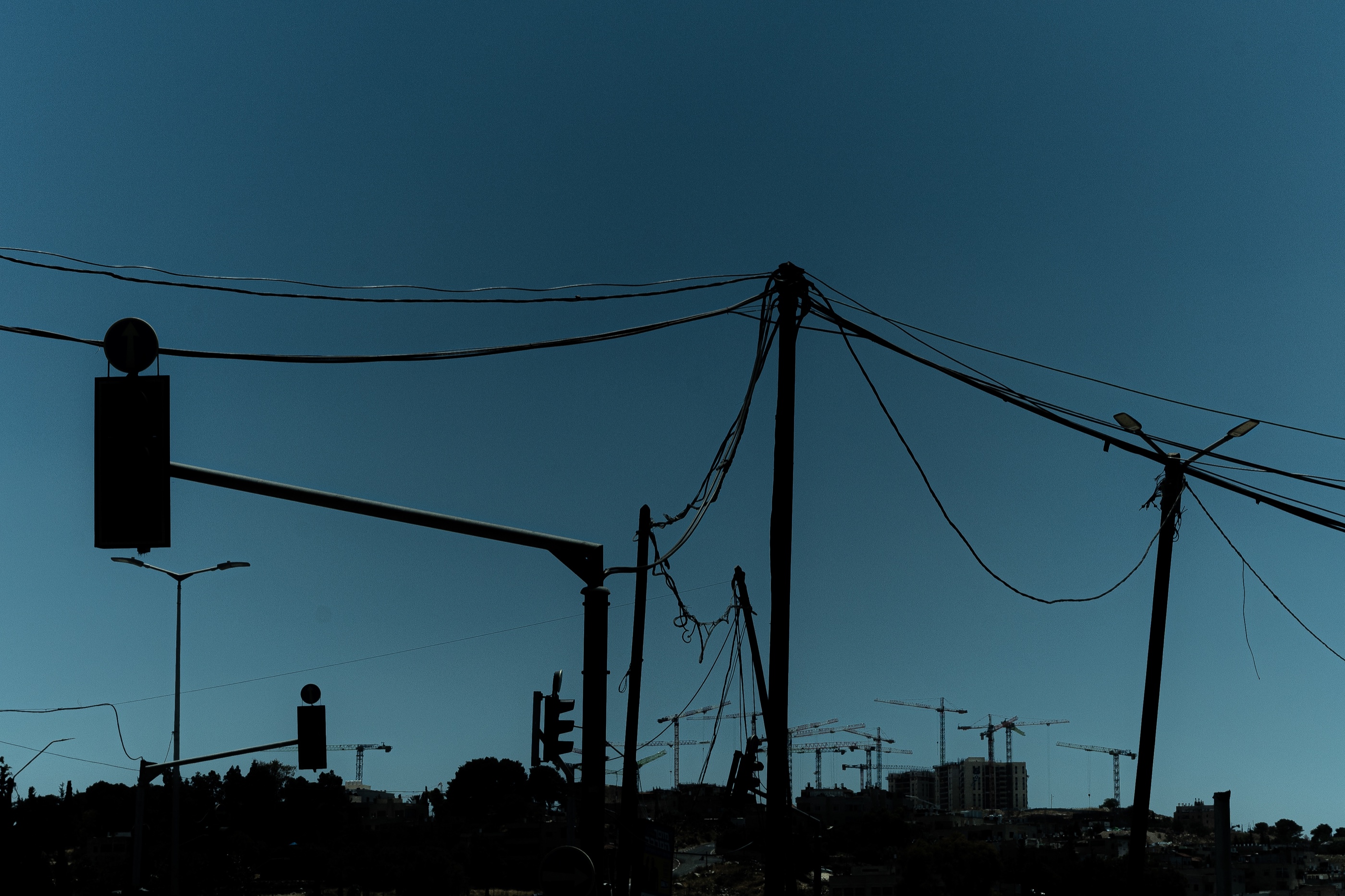 Power lines crossing a deep blue Jerusalem sky